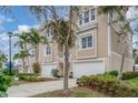 Tan three-story home with attached garage and lush landscaping at 10311 Lands End Cir # 13, Placida, FL 33946