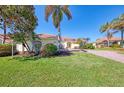 House exterior showcasing a yellow house with a red tile roof and lush landscaping at 3487 Pennyroyal Rd., Port Charlotte, FL 33953