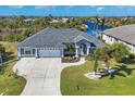 Single-Gathering home with a gray exterior, two-car garage, and a well-maintained lawn at 10083 Kansas City St, Port Charlotte, FL 33981