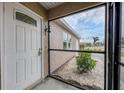 Front entrance with white door and screened porch at 19483 Midway Blvd, Port Charlotte, FL 33948