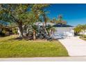 White house with a green lawn, palm trees, and a driveway at 217 Rotonda Cir, Rotonda West, FL 33947