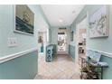 Inviting hallway with coastal decor and tile flooring leading to other rooms in the home at 404 Pine Hollow Cir # 404, Englewood, FL 34223