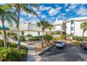 Condo building exterior showcasing attractive landscaping and parking area at 5000 Gasparilla Rd # Dc206, Boca Grande, FL 33921