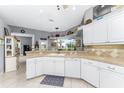 Bright kitchen with white cabinets, tile countertops, and a window overlooking the backyard at 848 Boundary Blvd, Rotonda West, FL 33947