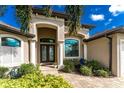 House entrance with columns, double doors, and lush landscaping at 230 Long Meadow Ln, Rotonda West, FL 33947