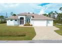 House with a three car garage and paver driveway at 12194 Everglades Ave, Port Charlotte, FL 33981