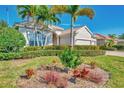 Landscaped yard with palm trees and colorful flowers at 13025 Cedar Creek Dr, Port Charlotte, FL 33953