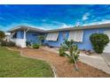 Front walkway to light blue home with white shutters and well maintained landscaping at 189 Carlisle Nw Ave, Port Charlotte, FL 33952