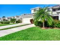 Two-story house exterior with a garage and lush landscaping at 3393 Grand Vista Ct # 201, Port Charlotte, FL 33953