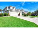 Two-story house exterior with a garage, landscaping and palm tree at 3393 Grand Vista Ct # 201, Port Charlotte, FL 33953