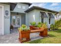 Front porch with a wooden bench and potted plants at 137 Wahoo Dr, Rotonda West, FL 33947
