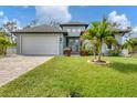 Single-story home with a two-car garage and landscaping at 137 Wahoo Dr, Rotonda West, FL 33947