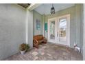 Charming covered entrance featuring a wooden bench and double glass doors at 137 Wahoo Dr, Rotonda West, FL 33947
