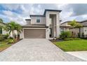 Two-story house with neutral siding, a taupe garage door, and a paved driveway at 19524 Fishhawk Trl, Venice, FL 34293