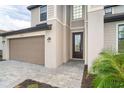 Exterior view of a two-story home showcasing landscaping and a taupe garage door at 19524 Fishhawk Trl, Venice, FL 34293