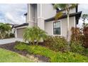 Exterior view of a two-story home showcasing landscaping and a taupe garage door at 19524 Fishhawk Trl, Venice, FL 34293