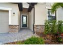 Front entrance with stone accents and a dark gray door at 19536 Fishhawk Trl, Venice, FL 34293