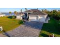 Two-story house with a gray exterior, white garage doors, and a paved driveway at 2408 Vance Ter, Port Charlotte, FL 33981