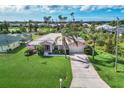 House with a large yard, driveway and American flag at 3 Pinehurst Ct, Rotonda West, FL 33947