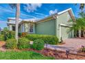 Green house exterior with lush landscaping and brick walkway at 3155 Osprey Ln, Port Charlotte, FL 33953