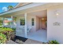 Covered porch with white wicker furniture and landscaping at 3270 Bay Ridge Way, Port Charlotte, FL 33953