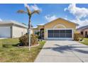 Exterior view of a single-story house with a two-car garage and palm tree at 4261 Oak Terrace Cir, Port Charlotte, FL 33953