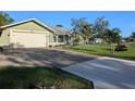 Single story home with green exterior, attached garage, and spacious lawn at 705 Chevy Chase Nw St, Port Charlotte, FL 33948