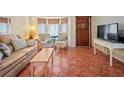 Bright living room with comfy seating, a coffee table, and terracotta tile floors at 7209 Mamouth St, Englewood, FL 34224