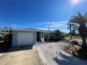 Front view of a single-story home with a white garage door and palm trees at 9 Annapolis Ln, Rotonda West, FL 33947