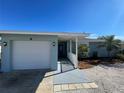 Light blue house with white garage door, walkway and landscaping at 9 Annapolis Ln, Rotonda West, FL 33947