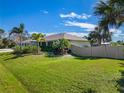 Side view of the house showing the backyard and gray fence at 9431 Prospect Ave, Englewood, FL 34224