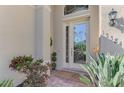 Front entry with glass door, etched design, and lush landscaping at 13384 Creekside Ln, Port Charlotte, FL 33953