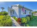 Light blue house with American flag and lush landscaping at 14439 Worthwhile Rd, Port Charlotte, FL 33953