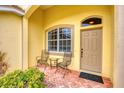 Front porch with two metal chairs and a small table at 1985 Coconut Palm Cir, North Port, FL 34288