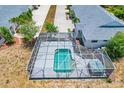 Aerial view of a screened-in pool and spa surrounded by lush landscaping on a sunny day at 268 Rotonda W Blvd # 1B, Rotonda West, FL 33947