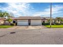 Two-unit villa building showcasing attached garages and well-maintained lawns at 618 Deerwood Ave, Englewood, FL 34223