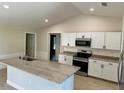 Modern kitchen with white cabinets, granite island, and stainless steel appliances at 9992 Antler St, Port Charlotte, FL 33981