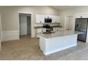 Open concept kitchen with white cabinets and large granite island at 9992 Antler St, Port Charlotte, FL 33981