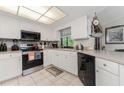 Modern kitchen with white cabinets, stainless steel appliances, and tile floor at 10127 Peach Ave, Englewood, FL 34224