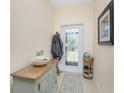 Entryway with a wooden console table, coat rack, and decorative door at 13488 Abercrombie Dr, Englewood, FL 34223