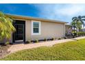 Back exterior view of a tan house with a screened patio and landscaped yard at 13488 Abercrombie Dr, Englewood, FL 34223