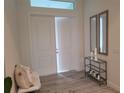 Bright entryway with tile flooring, a bench, and two mirrors at 14331 Montmarte Ave, Port Charlotte, FL 33981