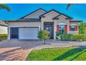 One-story house with orange shutters, a white garage door, and landscaping at 2148 La Palma Ave, Port Charlotte, FL 33953