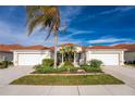 Exterior view of a charming villa with two-car garage and lush landscaping at 27168 Ipswich Dr, Englewood, FL 34223