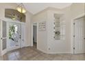 Bright and airy foyer with tile flooring and built-in shelving at 3300 Pennyroyal Rd, Port Charlotte, FL 33953