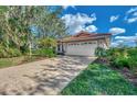 Front view of a house with a white garage door and paved driveway at 3300 Pennyroyal Rd, Port Charlotte, FL 33953