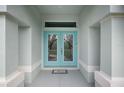 Light teal double front doors with glass inserts, leading into the home at 5272 Churchill Rd, Port Charlotte, FL 33981