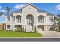 Two-story home with gray siding, metal roof, and landscaping at 10030 Eagle Preserve Dr, Englewood, FL 34224