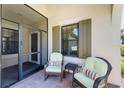 Screened porch with wicker chairs and side table at 11249 Mc Dermott Ct, Englewood, FL 34223