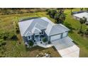 One-story house with gray roof, two-car garage, and fenced pool at 1131 Boundary Blvd, Rotonda West, FL 33947